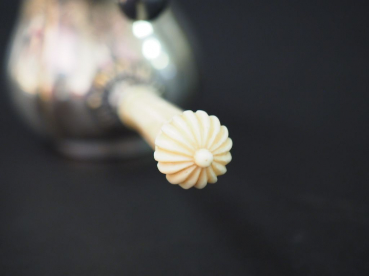 Réchaud de style Louis XIV en métal argenté, manche en ivoire tourné.