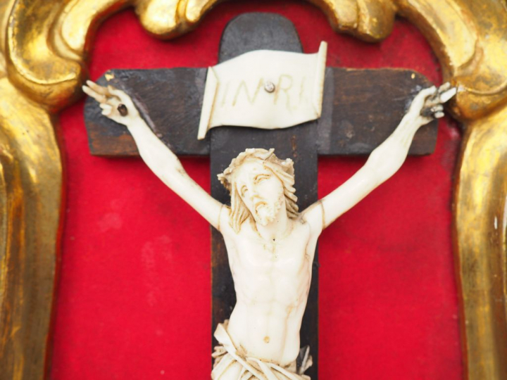 Crucifix en bois et ivoire dans un cadre en bois et stuc doré et ajour
