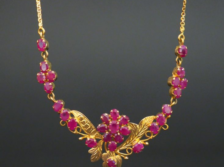 Pendentif et sa chaine en or orné de rubis à décor de fleurs. Poids te