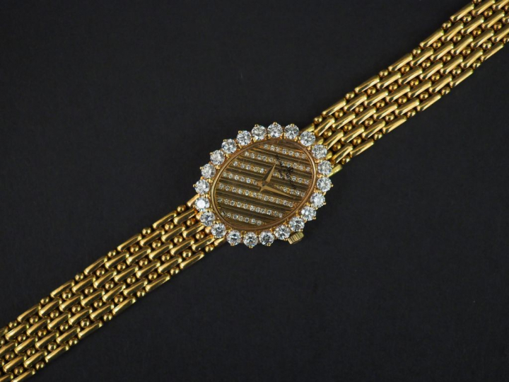 BAUME ET MERCIER. Montre de dame en or, cadran entouré de 22 diamants,