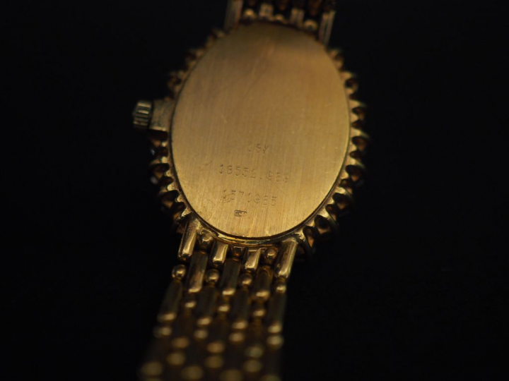 BAUME ET MERCIER. Montre de dame en or, cadran entouré de 22 diamants,