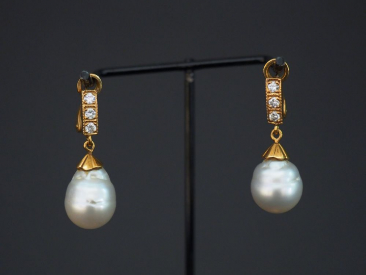 Paire de perce oreilles, perle baroque, or et trois diamants. Poids te