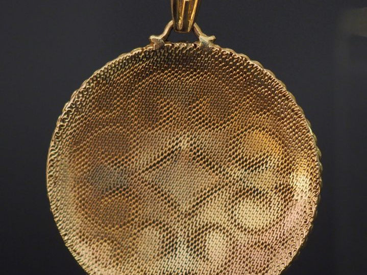 Pendentif en or gravé à décor d'entrelacs orné de quatre perles et de 