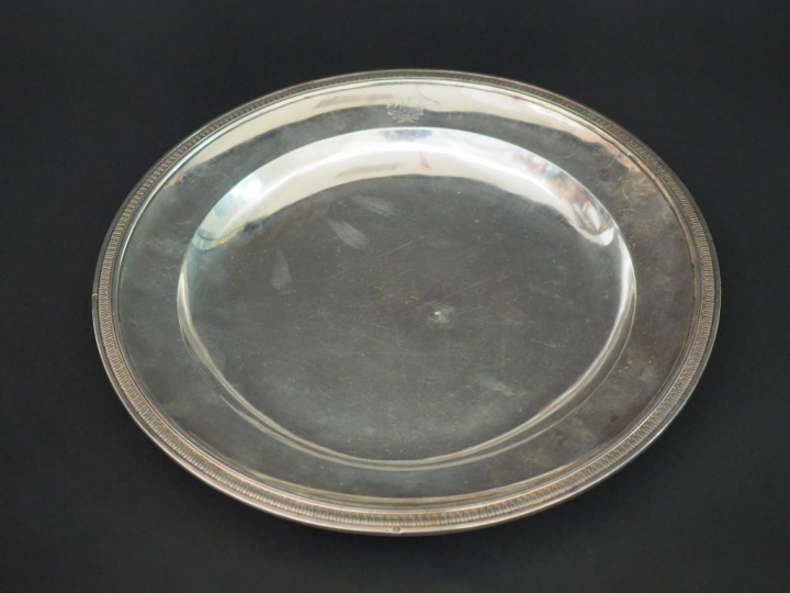 Plat rond début XIXème en argent, à décor d’une frise de feuilles d’ea
