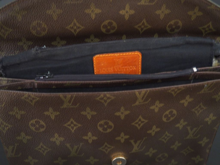 VUITTON. Pochette en toile Monogram marron  Dim.  28 x 18 cm (déchirur