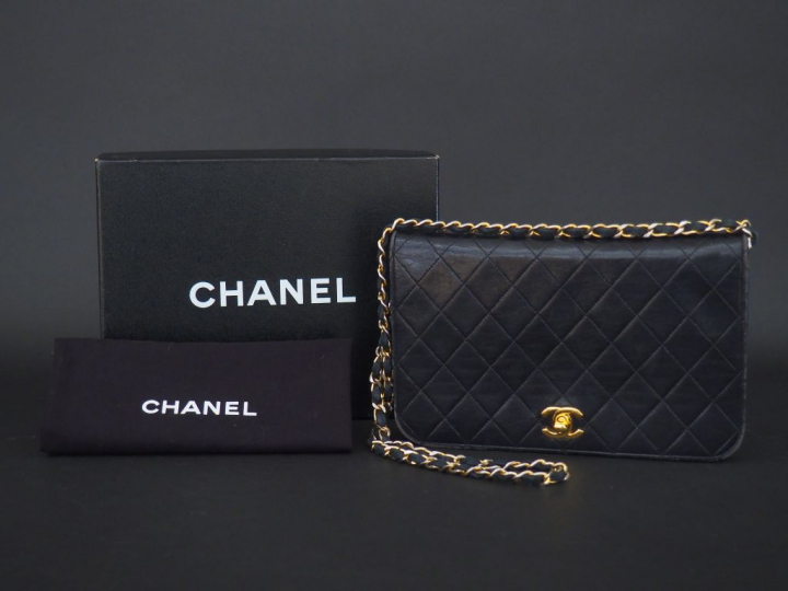 CHANEL. Sac à main en cuir noir matelassé. L.  23,5 cm  (quelques usur