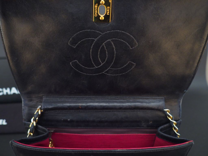 CHANEL. Sac à main en cuir noir matelassé. L.  23,5 cm  (quelques usur