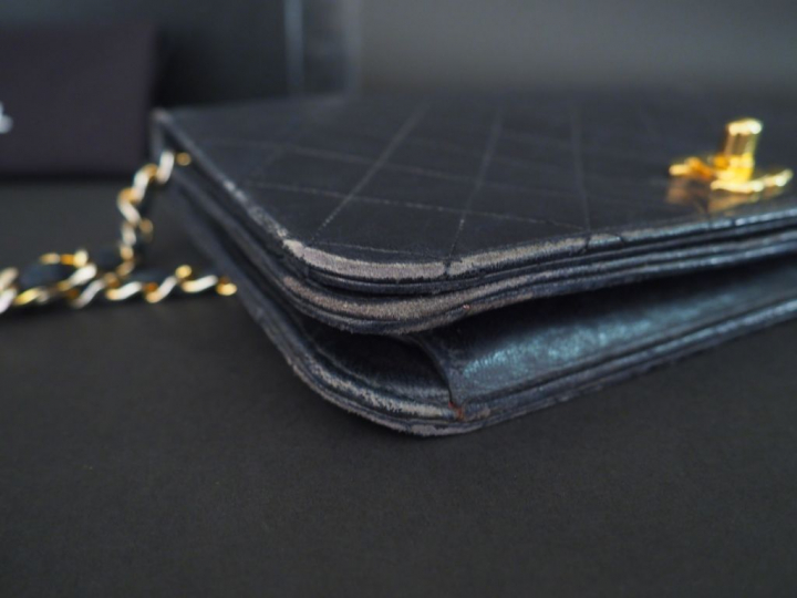 CHANEL. Sac à main en cuir noir matelassé. L.  23,5 cm  (quelques usur