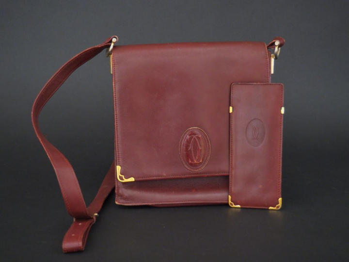 MUST DE CARTIER. Pochette en cuir marron H. 21 cm (état d'usage)  on y