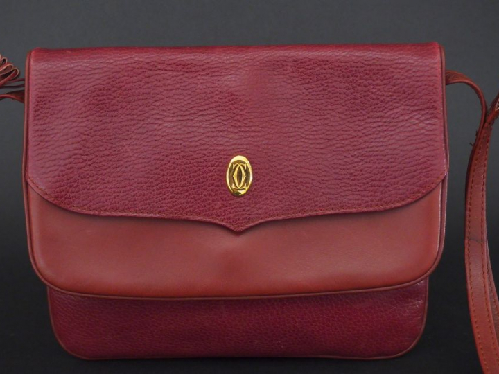 MUST DE CARTIER. Pochette en cuir marron H. 19 cm