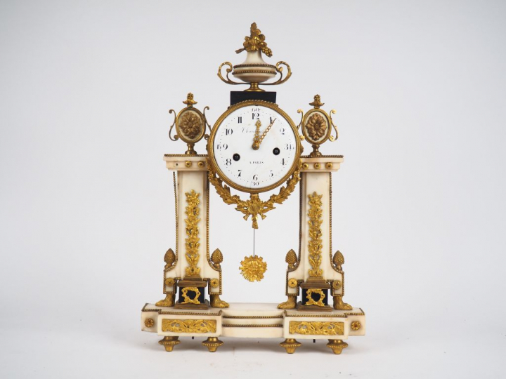 Pendule Louis XVI en marbre et bronze doré à décor de pommes de pins, 