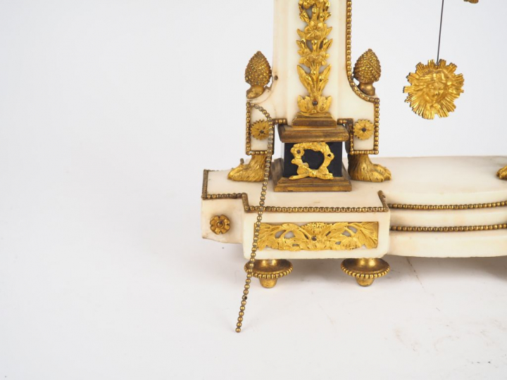 Pendule Louis XVI en marbre et bronze doré à décor de pommes de pins, 
