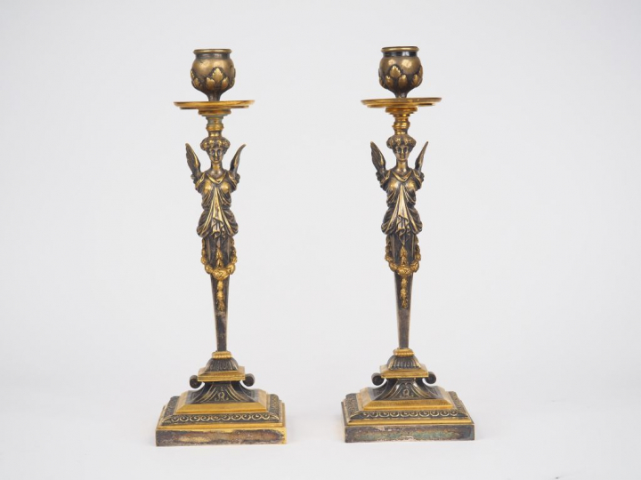 Paire de bougeoirs en bronze de style Empire à décor de femmes ailées.