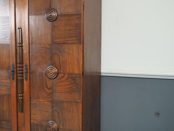 Charles DUDOUYT. Armoire en chêne tourné mouluré et sculpté à décor de