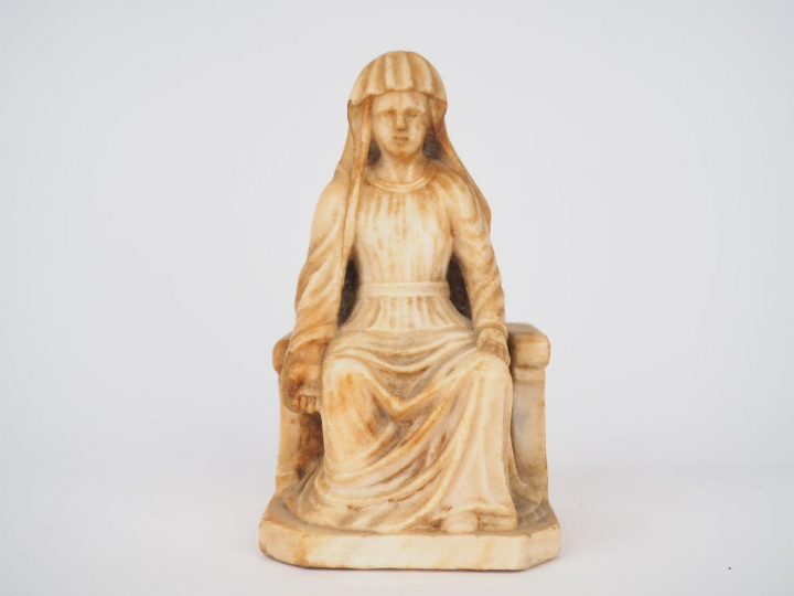 Vierge en albâtre sculpté en ronde-bosse. Assise sur un banc-trône orn