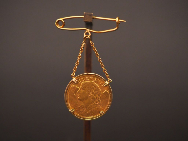 Broche en or jaune, ornée d’une pièce de 20 francs or suisse en pendel