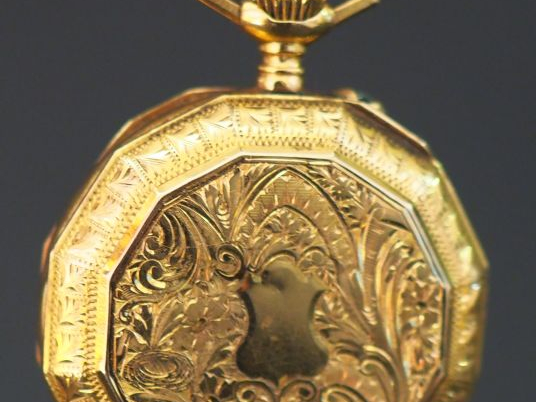 Montre de col en or jaune, à décor de cartouche et de motifs feuillagé