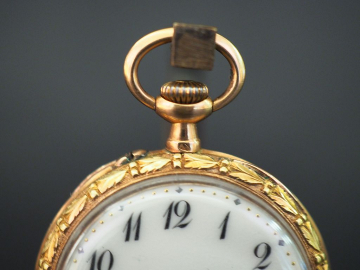 Montre de col en or jaune, à décor de guirlande de feuillage. Cadran é