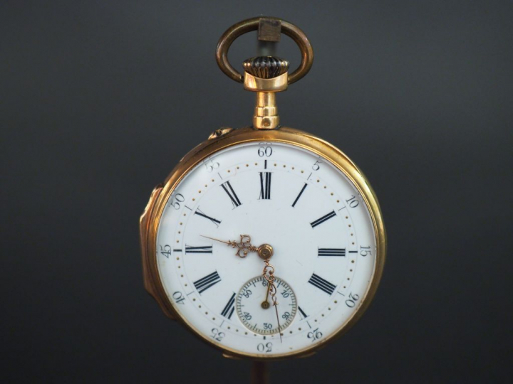 Montre de gousset en or jaune, le revers à décor de cartouche et de fe