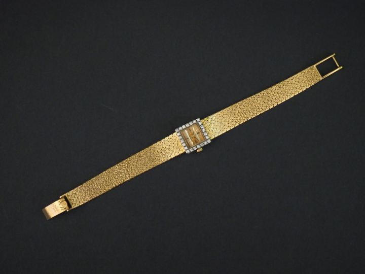 OMEGA. Montre bracelet de dame en or jaune. Bracelet souple, maille pl