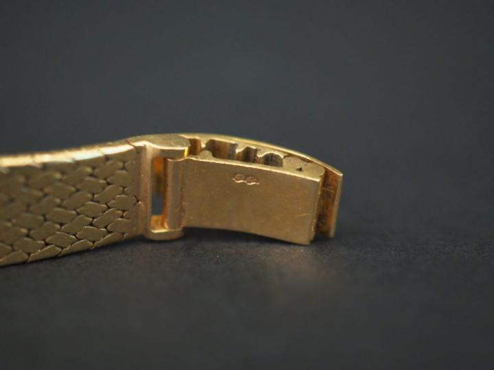 OMEGA. Montre bracelet de dame en or jaune. Bracelet souple, maille pl