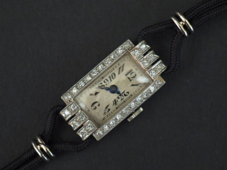 Vente aux enchères 	Montre bracelet de dame de style Art déco.  Boitier en platine et or 