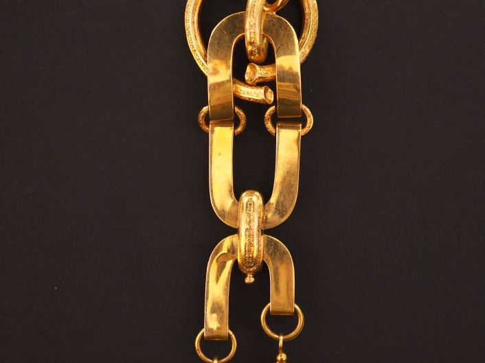 Chatelaine en or jaune, à décor de motifs stylisés.  Attache en vermei