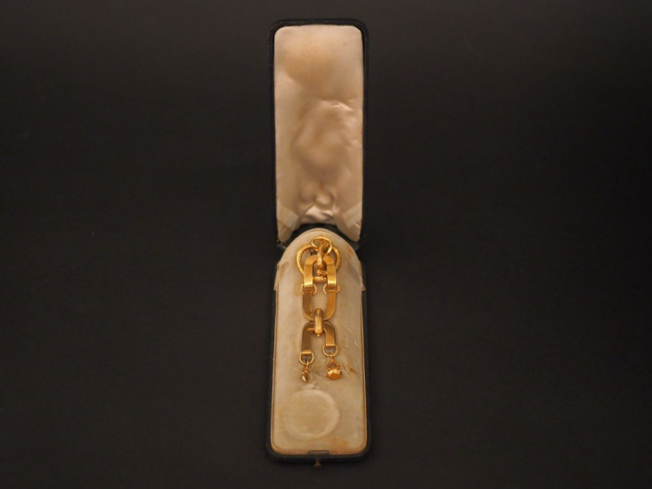 Chatelaine en or jaune, à décor de motifs stylisés.  Attache en vermei