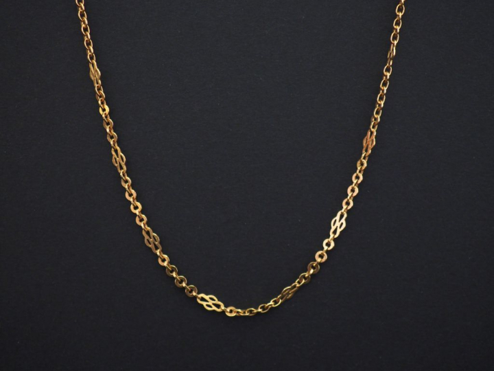 	Sautoir en or jaune, maille forçat alterné de maillons quadrilobés. L