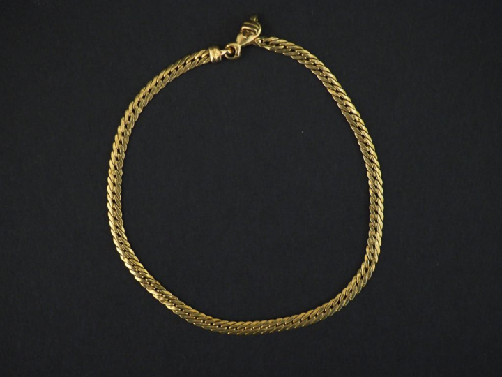 Bracelet articulé en or jaune, maille plate gourmette.  Long. 17 cm  P