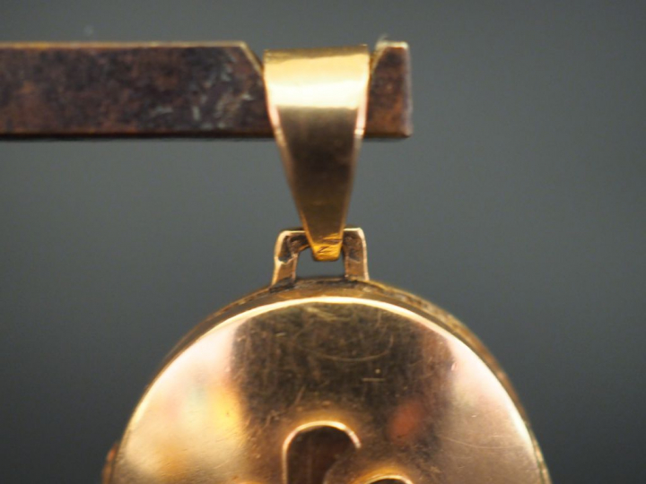 Pendentif porte-photo en or jaune, à décor appliqué de monogramme. Poi