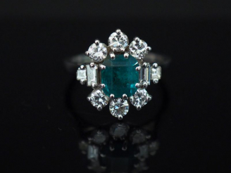 Vente aux enchères Bague marguerite en or blanc, sertie en son centre d’une émeraude ento