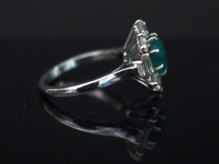 Bague marguerite en or blanc, sertie en son centre d’une émeraude ento