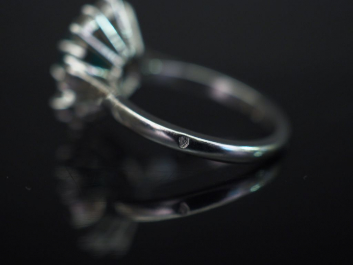 Bague marguerite en or blanc, sertie en son centre d’une émeraude ento