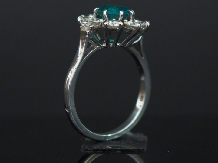 Bague marguerite en or blanc, sertie en son centre d’une émeraude ento