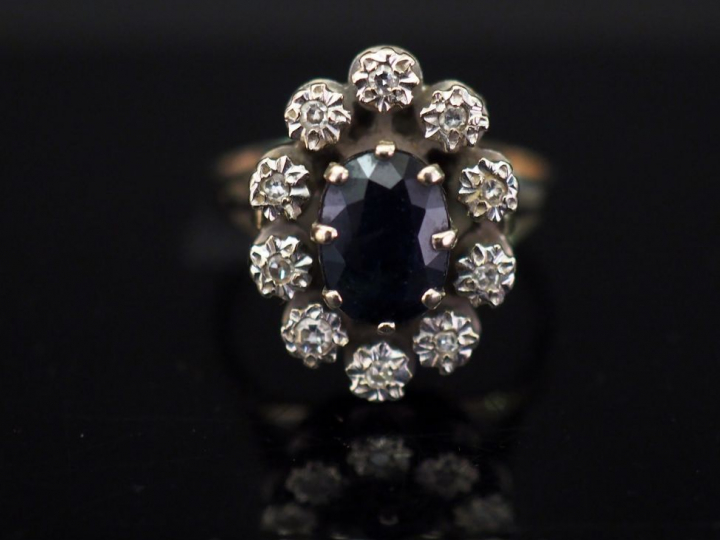 Bague marguerite en or blanc, sertie en son centre d'une pierre bleue 