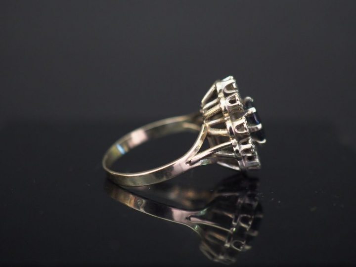 Bague marguerite en or blanc, sertie en son centre d'une pierre bleue 