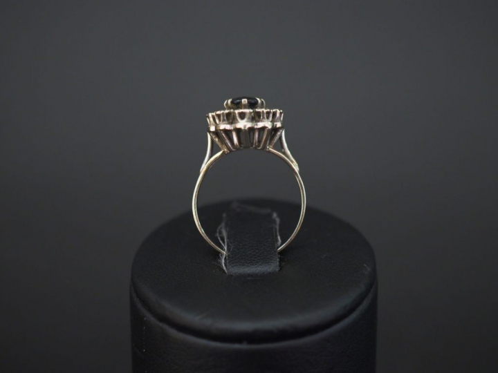 Bague marguerite en or blanc, sertie en son centre d'une pierre bleue 