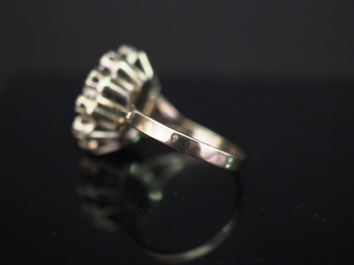 Bague marguerite en or blanc, sertie en son centre d'une pierre bleue 