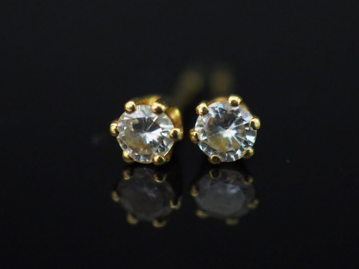 Paire de puces d’oreilles en or jaune, serties d’un petit diamant. Poi