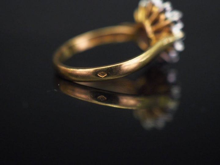	Bague marguerite en or jaune, sertie en son centre d’un rubis entouré