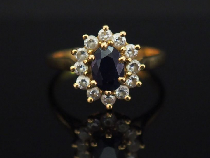 	Bague marguerite en or jaune, sertie en son centre d’une pierre bleue