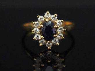 Vente aux enchères 	Bague marguerite en or jaune, sertie en son centre d’une pierre bleue