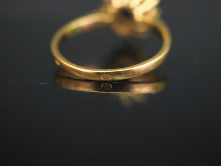 	Bague marguerite en or jaune, sertie en son centre d’une pierre bleue