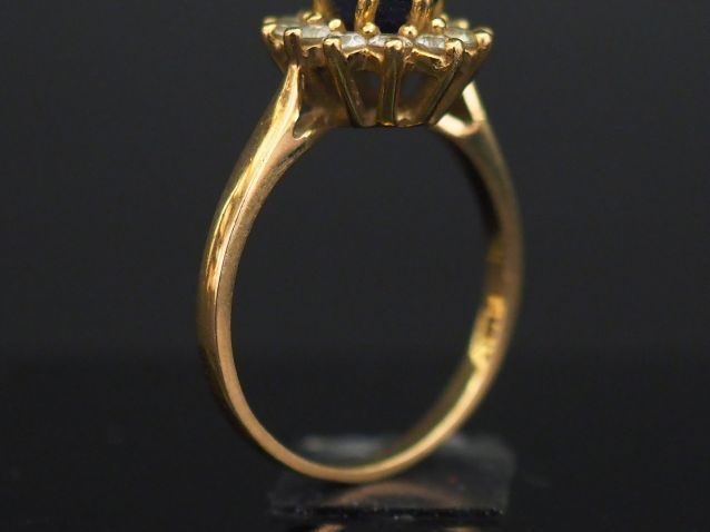 	Bague marguerite en or jaune, sertie en son centre d’une pierre bleue