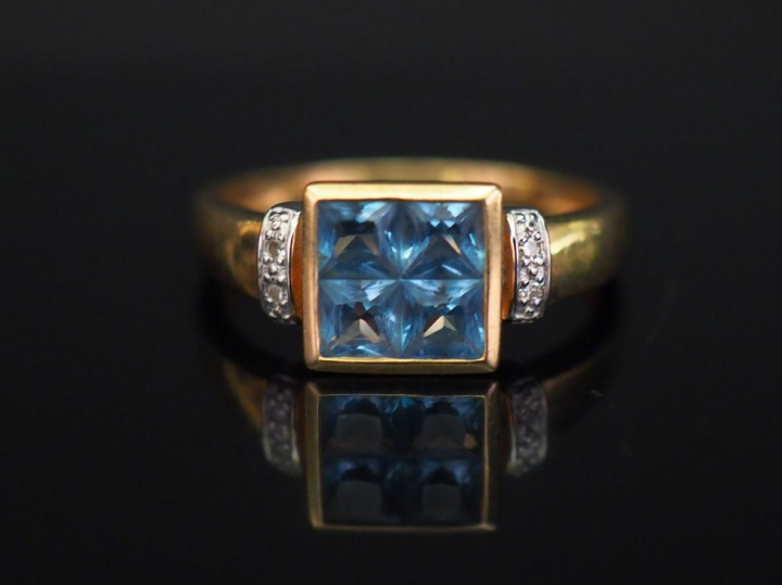 Bague en or jaune, sertie en son centre d’une pierre bleue.  Monture a