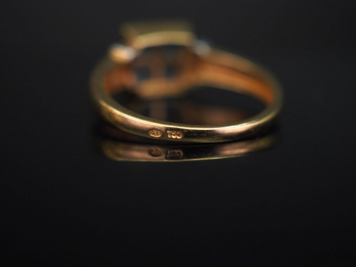 Bague en or jaune, sertie en son centre d’une pierre bleue.  Monture a