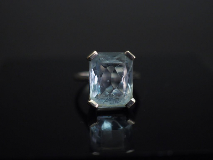 	Bague en or banc, sertie en son centre d’une pierre bleue. TDD. 52 Po