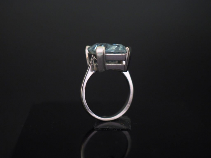 	Bague en or banc, sertie en son centre d’une pierre bleue. TDD. 52 Po