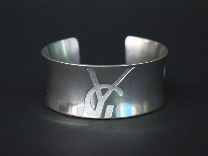 	Bracelet manchette en argent, à décor d’un monogramme.  Poids. 57 g